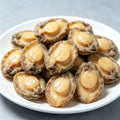 Plump abalone meat arranged on a white plate