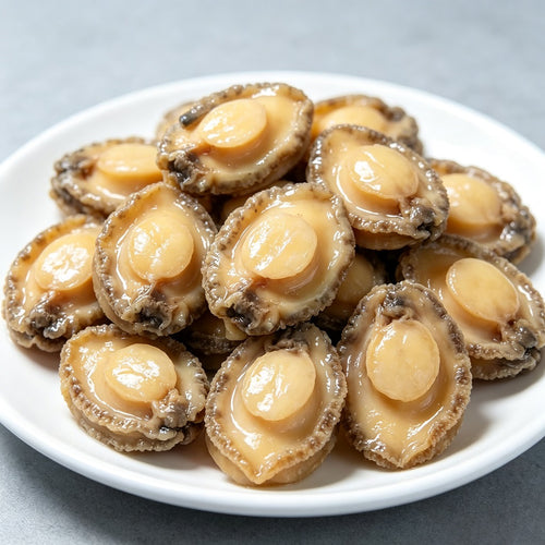Plump abalone meat arranged on a white plate